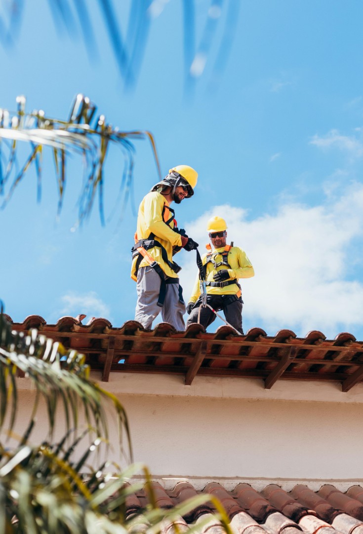 Proffesionals installing tiles on a new roof
