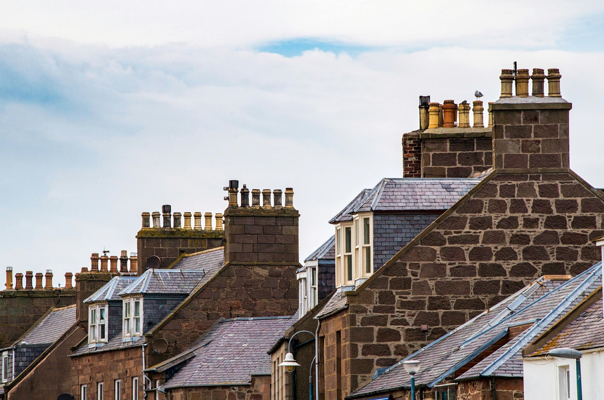 roofs of houses in a neighborhood under a blue sky